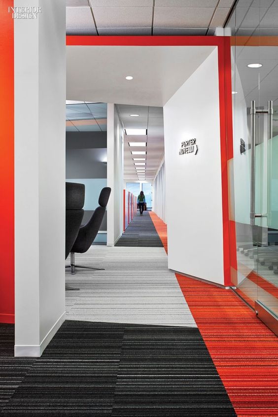 Brightly coloured geometric wall-to-wall carpeting in a well-lit modern office design