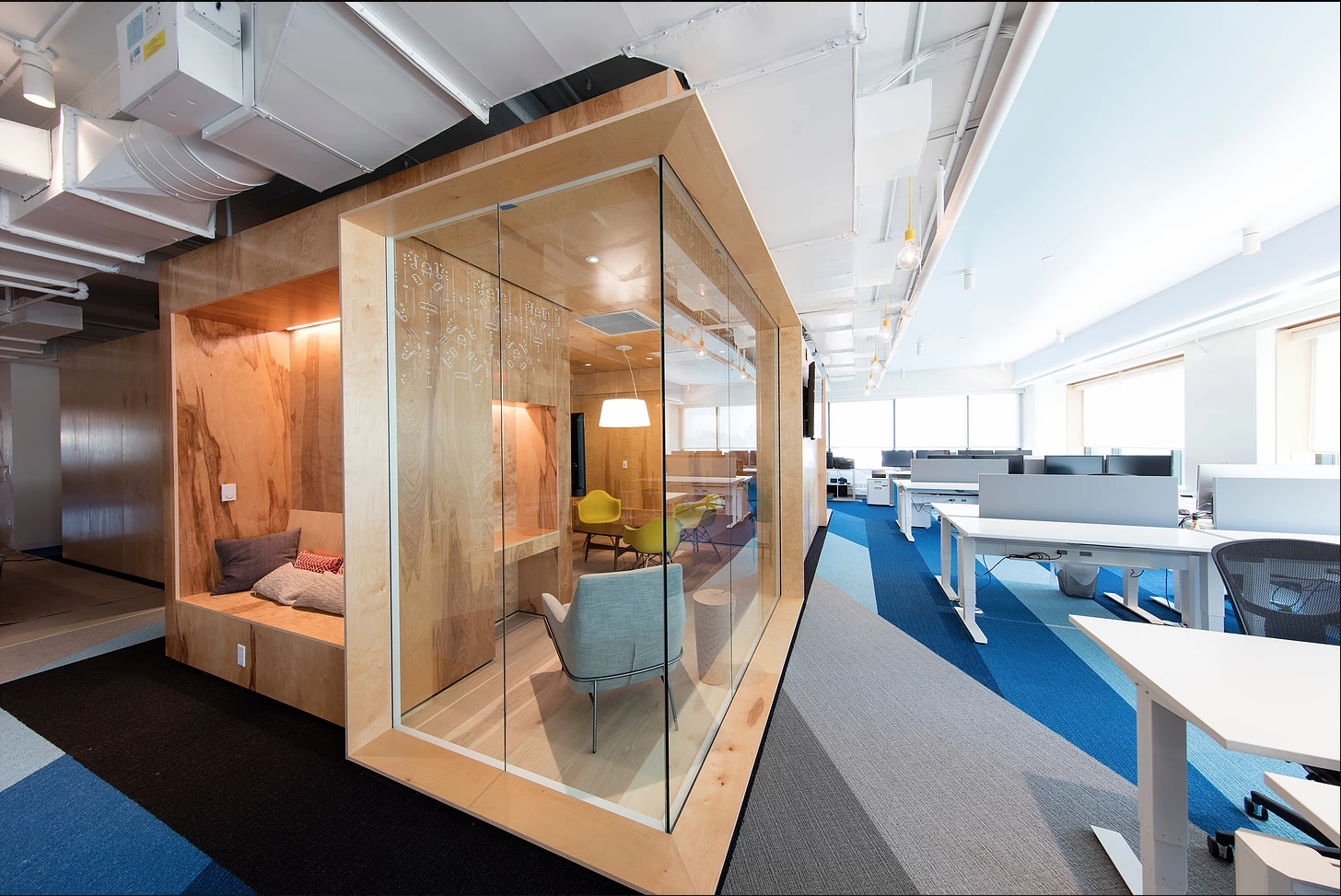 Office lounge or meeting area fully enclosed in glass in open concept office design